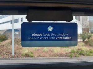 Bus window sign saying "please keep this window open to assist with ventilation"